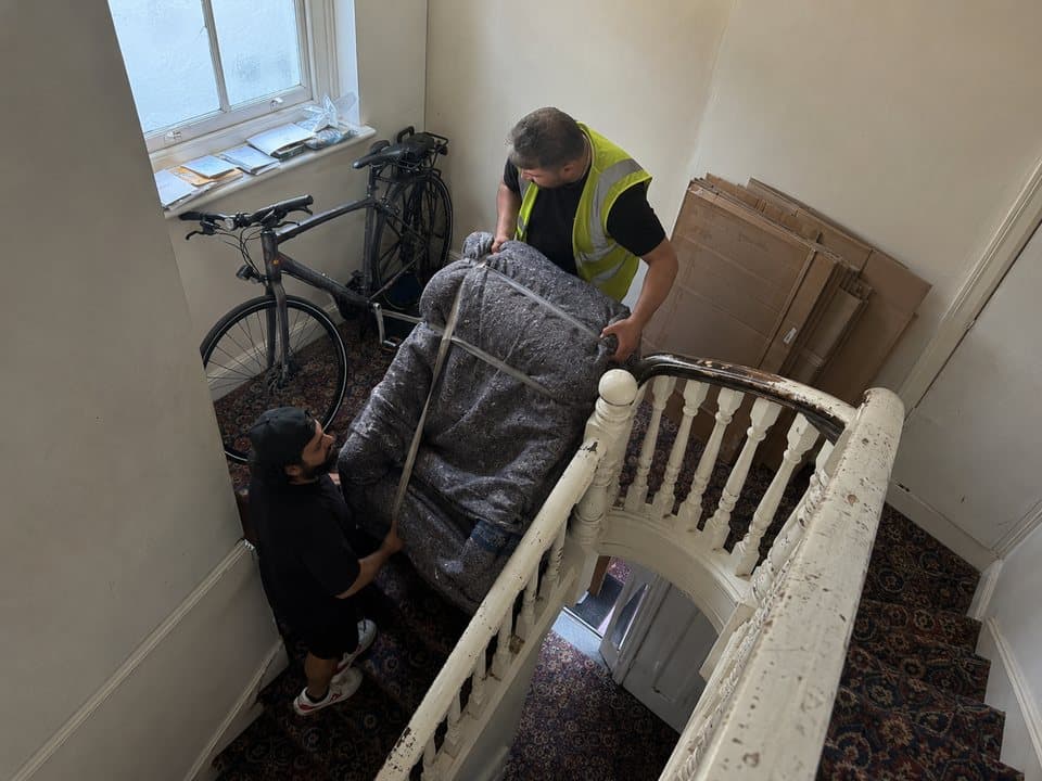 Flat removals in London: wrapped cabinet on a trolley being taken through a communal lift lobby